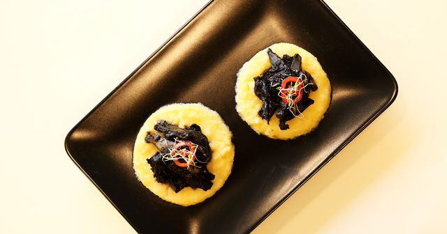 Black cuttlefish ink with polenta and cherry tomatoes