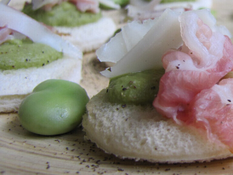 Canapè with broad bean cream, crunchy bacon and sheep milk cheese flakes